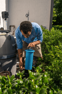 Safari Pool Service Employee Cleaning Out Filter