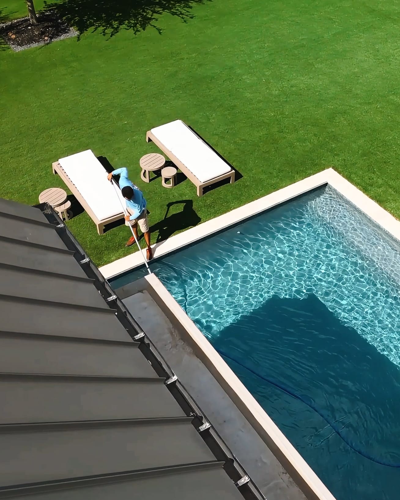 Corner Aerial View Of Technician Doing Weekly Pool Maintenance