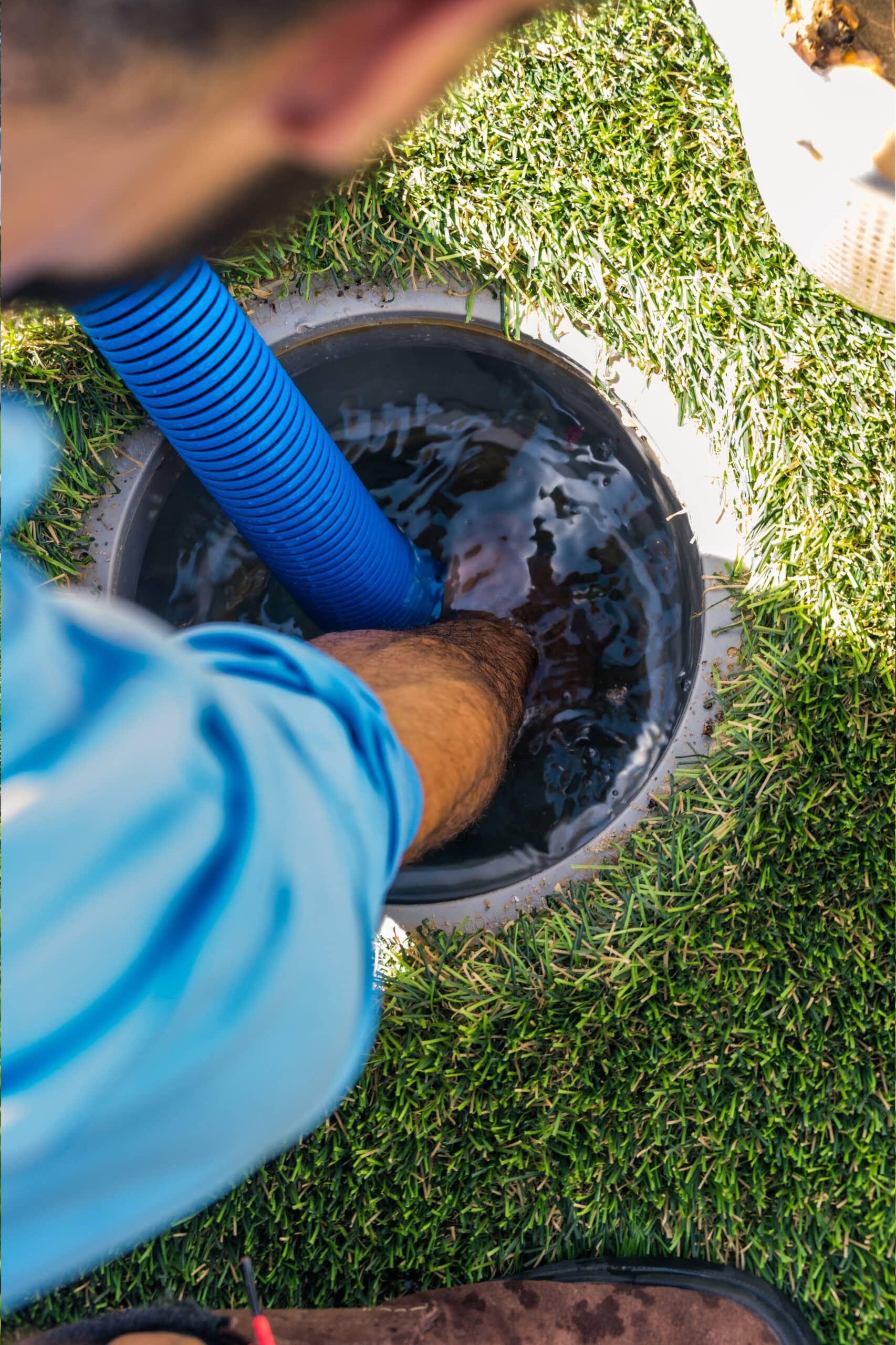 Technician Vacuuming Pool In Ground Skimmer